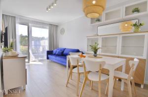 a kitchen and living room with a table and chairs at Sunset Apartments - Roosevelta - Premium - Garaż in Świnoujście