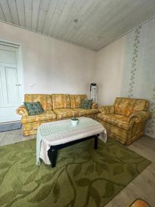 a living room with two couches and a coffee table at Tamsalu Wallamaja in Tamsalu