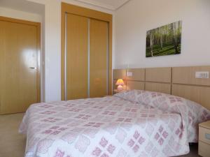 a bedroom with a bed with a pink and white bedspread at Playa R84MED010 in La Estación +8 photos