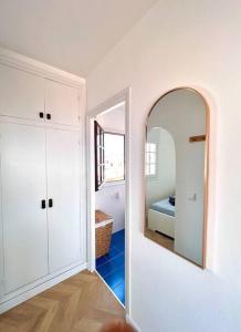 Cette chambre blanche dispose d'un miroir et d'un lit. dans l'établissement Ático con vistas al mar Cala enPorter, à Cala'n Porter 12 autres photos