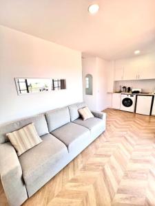 un salon avec un canapé et une cuisine dans l'établissement Ático con vistas al mar Cala enPorter, à Cala'n Porter