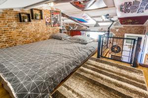 ein großes Bett in einem Zimmer mit Ziegelwand in der Unterkunft Industrial style studio house Eni, with Parking, BBQ, AC in Marčana, Ferienwohnung in Marčana