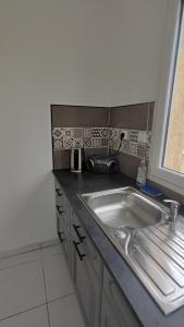 un bancone della cucina con lavandino e finestra di Appartement cosy a Uchaud