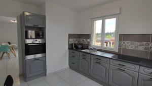 a kitchen with gray cabinets and a window in it at Appartement cosy in Uchaud