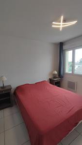 una camera con letto rosso e finestra di Appartement cosy a Uchaud