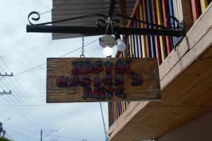 a sign with a teddy bear hanging from a building at Hostal Música y Arte in San Agustín