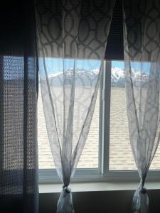 una ventana con vistas a las montañas en Rhodopa Guest House at Yellowstone #9, en Gardiner