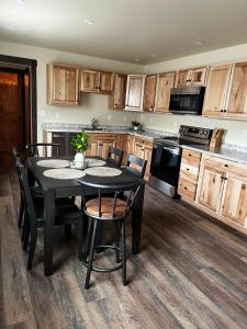 cocina con mesa negra y sillas en Rhodopa Guest House at Yellowstone #9, en Gardiner