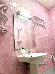 a pink bathroom with a sink and a mirror at Jolie Appt à skhirat 5min de la plage par voiture in Skhirat +12 photos