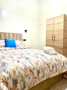 um quarto com uma cama grande e uma almofada azul em Jolie Appt à skhirat 5min de la plage em Skhirat