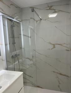 łazienka z przeszkloną kabiną prysznicową i umywalką w obiekcie Agua Mundo studio w mieście Benidorm