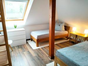 a room with two beds and a window at Ferienwohnung Am Waldesrand - Garten, Terrasse, Grill, Massagesessel, Kinderspielecke, Spielekonsole in Cottbus