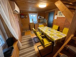 a dining room with a table and yellow chairs at Sarapuu puhkemaja in Hullo