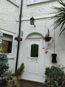 a white door on a white house with plants at The Summit in Kidderminster