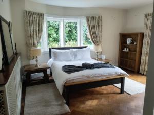 a bedroom with a bed and two windows at The Summit in Kidderminster