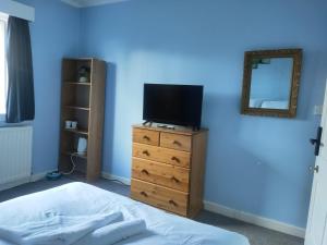 Dormitorio con cama y tocador con TV en The Summit en Kidderminster