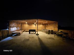 卡拉奇的住宿－Syed Rest House，一座木结构建筑,在黑暗中设有长椅和桌子
