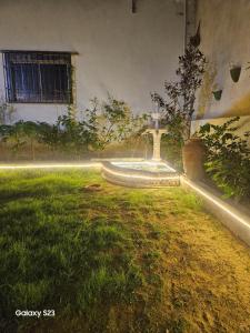 a fountain in the middle of a yard with grass at Syed Rest House in Karachi