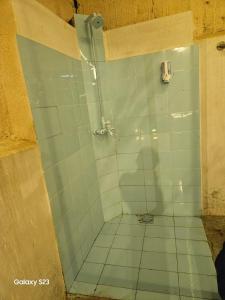 a bathroom with a shower with a tiled floor at Syed Rest House in Karachi