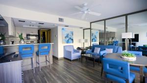 a kitchen and living room with blue chairs and a table at The Dover House Resort in Delray Beach