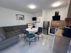 - un salon avec un canapé, une table et des chaises dans l'établissement Apartments Puntamika, à Zadar