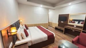 - une chambre d'hôtel avec un lit et un miroir dans l'établissement Hotel Ocean Hill, à Manali