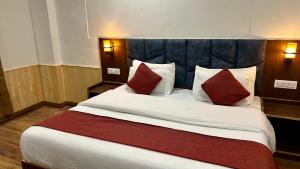 a bedroom with a large bed with red pillows at Hotel Ocean Hill in Manāli