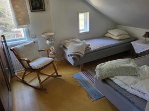 een slaapkamer met een bed, een stoel en een raam bij Lantligt äldre 1,5 plans hus. in Strömstad