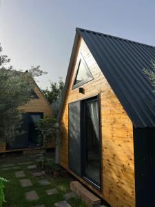 a wooden cabin with a black roof at Karaağaç Bungalov & Tiny House in Hatay