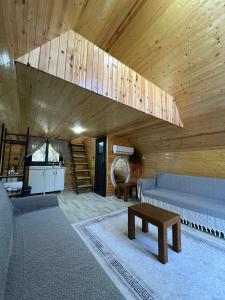 ein Wohnzimmer mit einem Sofa und einer Holzdecke in der Unterkunft Karaağaç Bungalov & Tiny House in Hatay