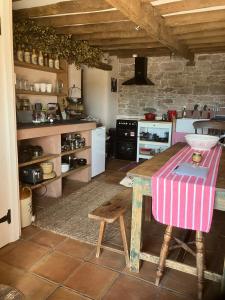 a kitchen with a wooden table and a counter top at Historic converted byre in courtyard of 16C house in Caldbeck