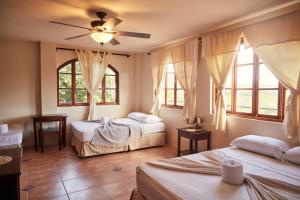 two beds in a room with windows and a ceiling at Beachside stay at Villa ViYarte in San Juan del Sur