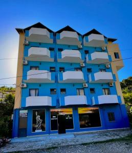 - un bâtiment bleu avec des balcons blancs sur le côté dans l'établissement Hotel Adriatik Shengjin, à Shëngjin