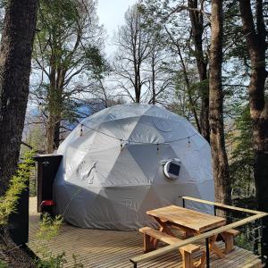 マラルカウエリョにあるMalalcahuello Eco Glampのデッキ(ピクニックテーブル付)が備わるテント