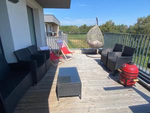 a patio with chairs and a hammock on a house at Kunigiškiai Mano Jūra2 apartamentai in Palanga