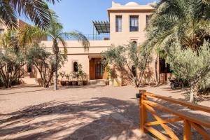 a building with a fence in front of it at Villa May sur le Golf de la Palmeraie with Cooker and Butler included in Marrakech