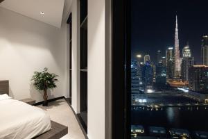 una camera da letto con vista sulla città di notte di Esclusive 1BR full Burj Khalifa View a Dubai Altre 37 foto
