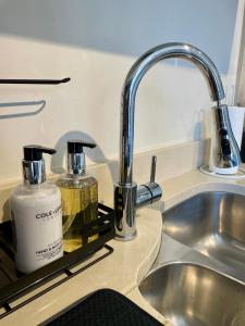 a kitchen sink with a soap dispenser and a bottle of soap at 3-Bedroom Luxury Stay With FREE Parking in Market Harborough