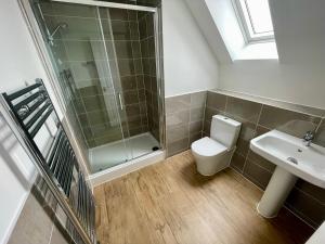 a bathroom with a shower and a toilet and a sink at 3-Bedroom Luxury Stay With FREE Parking in Market Harborough