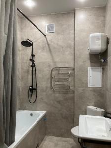 ein Badezimmer mit einer Dusche, einer Badewanne und einem WC in der Unterkunft Alpamys Premium центр города in Qostanai + 6 Fotos