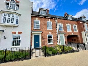 a large brick house with a blue door at 3-Bedroom Luxury Stay With FREE Parking in Market Harborough