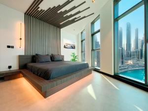 una camera da letto con un letto grande e grandi finestre di Esclusive 1BR full Burj Khalifa View a Dubai