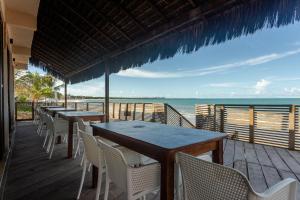 um restaurante com mesas e cadeiras na praia em Pousada Un Paso del Mar em Porto de Galinhas