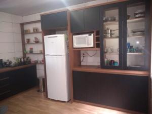 een keuken met een witte koelkast en een magnetron bij Sunshine in Gramado