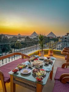 Almas Pyramids Hotel في القاهرة: طاولة مع أطباق من الطعام فوق شرفة