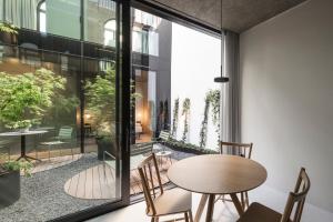 a room with a table and chairs and a large window at Mynt Merano Rooms in Merano