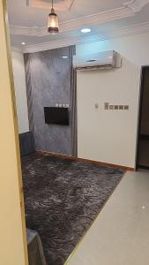una habitación vacía con puerta y alfombra en جوهرة المطار, en Al Mikhlaf