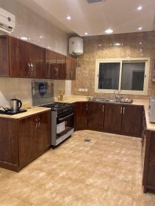 a kitchen with wooden cabinets and a stove top oven at شقق ارفلون دخـول ذاتي in Riyadh
