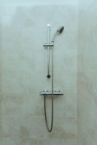 a shower with a hose in a bathroom at Detached Home with Aircon, Patio, BBQ, Pool Table & Table Tennis in Quinton