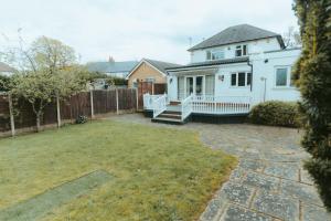 a white house with a fence and a yard at Detached Home with Aircon, Patio, BBQ, Pool Table & Table Tennis in Quinton